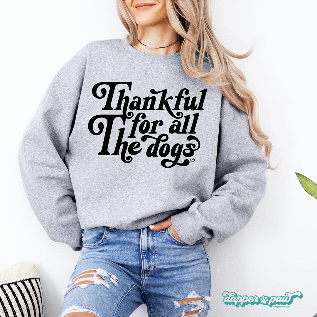 Woman in a gray "Thankful For All The Dogs" crewneck